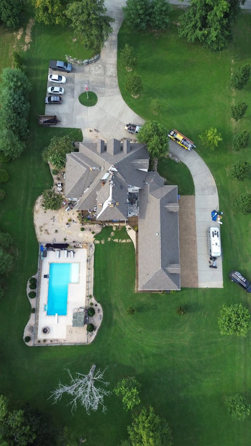 Aerial view of a roof replacement underway, with a Cross Driven truck in the driveway