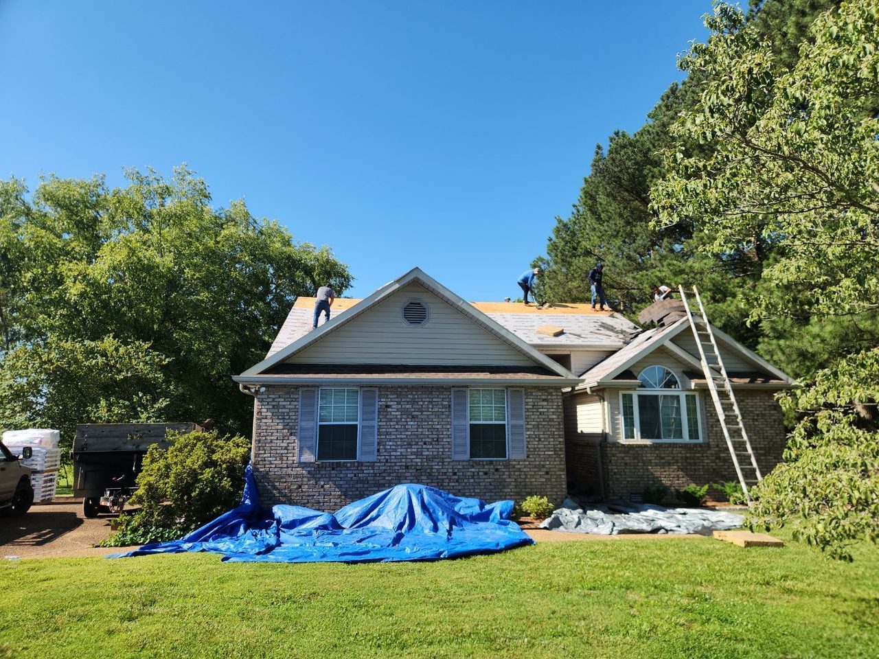 Crew re-roofing a hail-damaged house in Springfield, TN, full tear-off in progress